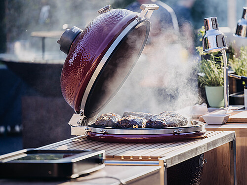Steaks auf einem Grill im Innenhof der Eventlocation Gut Wöllried im Rahmen eines BBQ-Caterings beim Winter BBQ