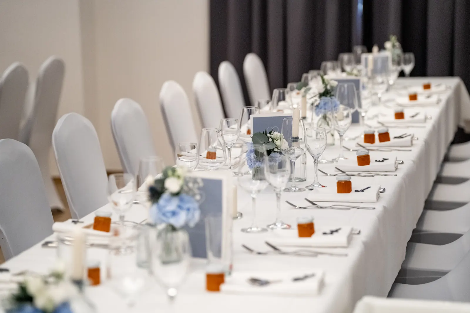Festlich gedeckte Hochzeitstafel mit Blumendekoration in der Brennerei von Gut Wöllried