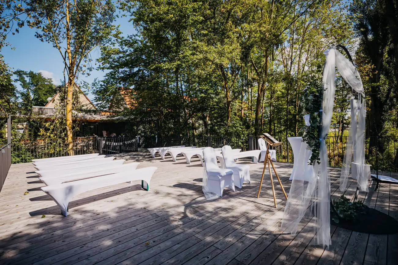 Terrasse des Ulrichssaals mit weißen Bänken und Traubogen für eine freie Trauung